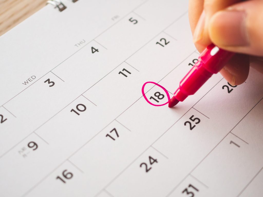 Female Hand with pen mark on calendar date