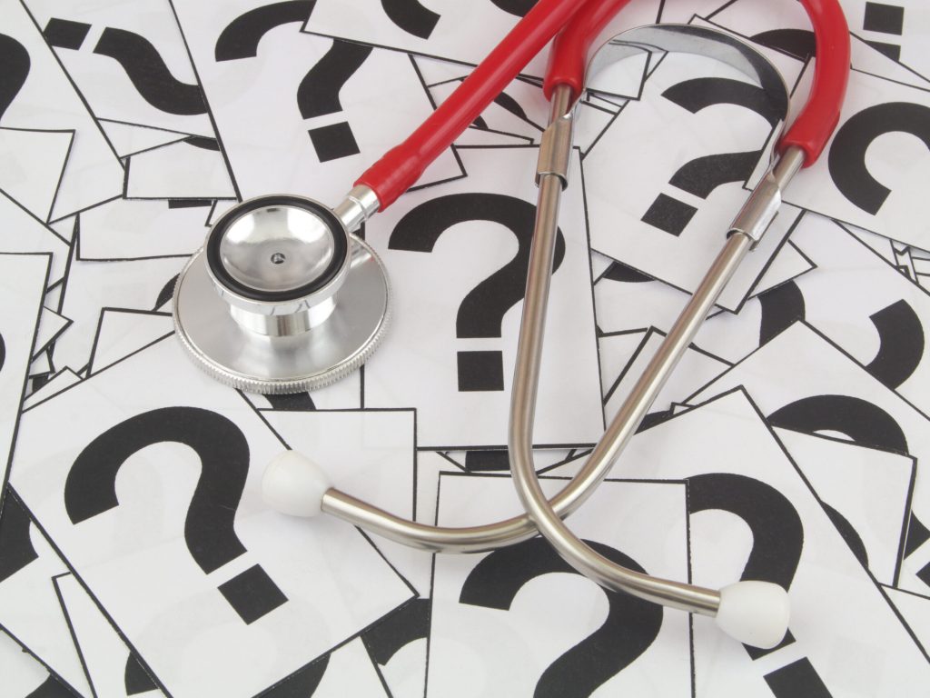 Medical FAQ concept. Stethoscope on many question marks.